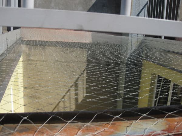 Protection d'une cour par pose d'un filet tressé en câble inox